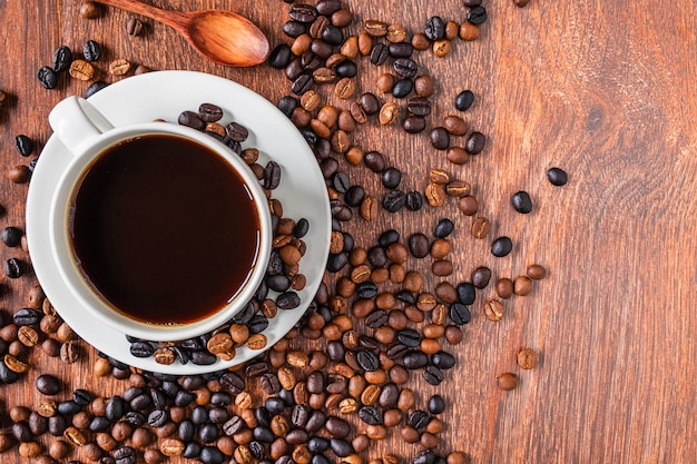 Kaffeetassen und Kaffeebohnen auf einem Holztisch