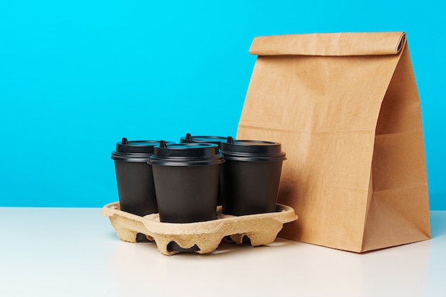 Kaffeetassen und Lebensmittelpaket zum Mitnehmen. Takeout Mahlzeit Konzept