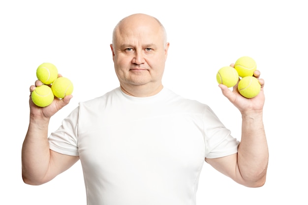 Kahler erwachsener Mann, der Tennisbälle in seinen Händen hält. Isoliert auf weißem hintergrund