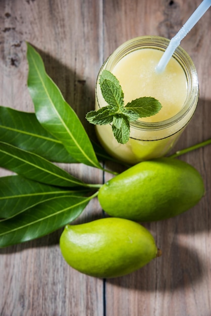 Kairi panha ou panna ou raw mango drink é uma bebida tradicional e popular no verão indiano servida em um copo sobre um fundo colorido ou de madeira. foco seletivo