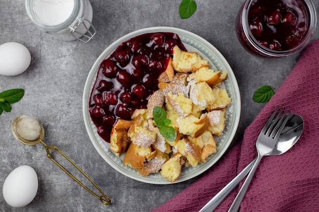 Kaiserschmarrn ist ein traditionelles österreichisches oder deutsches süßes Pfannkuchendessert mit Kirschsauce oder Marmelade.