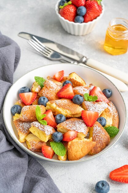 Kaiserschmarrn traditionelles österreichisches Pfannkuchendessert mit frischen Beeren und Puderzucker Kopierraum