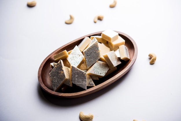 Kaju Katli é um doce indiano em forma de diamante feito com açúcar de caju e mava, servido em um prato sobre uma superfície temperada. foco seletivo