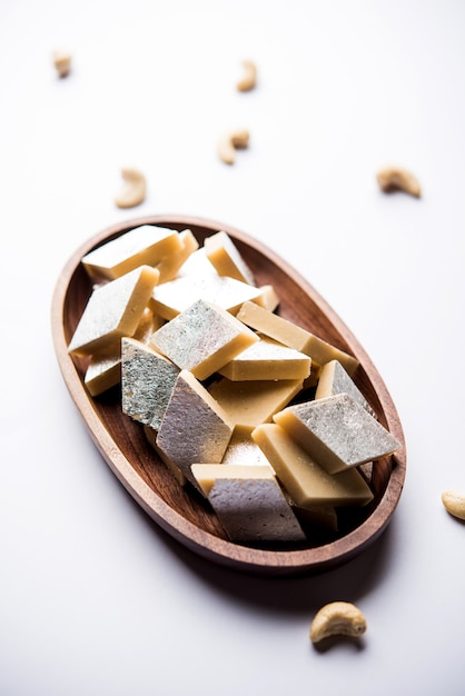 Kaju Katli é um doce indiano em forma de diamante feito com açúcar de caju e mava, servido em um prato sobre uma superfície temperada. foco seletivo