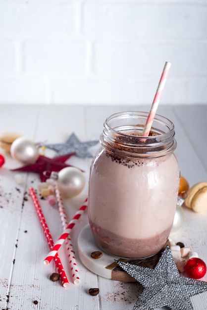 Kakao mit Eibisch und Strohhalmen im Glas mit Weihnachtsstern verziert