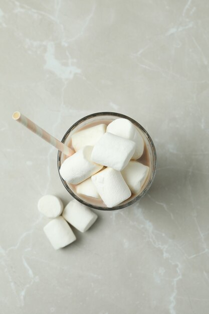 Kakao mit Marshmallows im Glas auf hellem Hintergrund