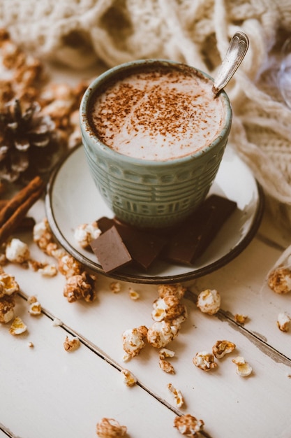Kakao-Schokoladen-Popcorn-Ingwer-Kekse und gestrickte Decke Gemütlicher Winterhaushintergrund