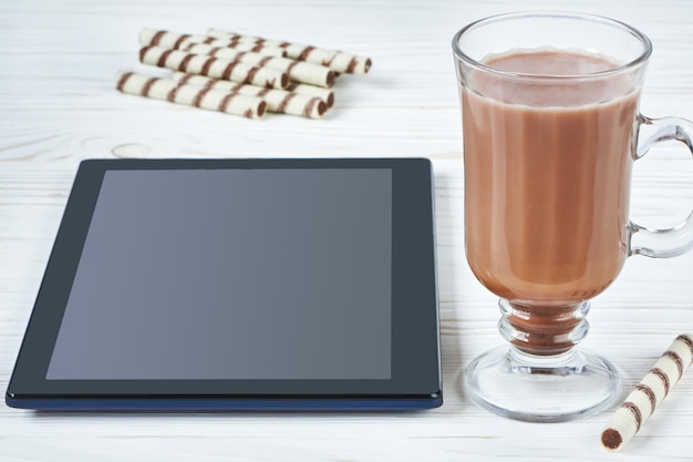 Foto kakaobecher gerollte waffel und tablet-pc