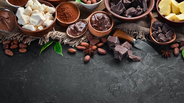 Kakaobohnen, Schokolade, Kakaobutter und Kakaopulver auf schwarzem Hintergrund Draufsicht Freier Kopierbereich