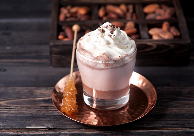 Kakaogetränk oder heiße Schokolade mit Schlagsahne und Kakaobohnen
