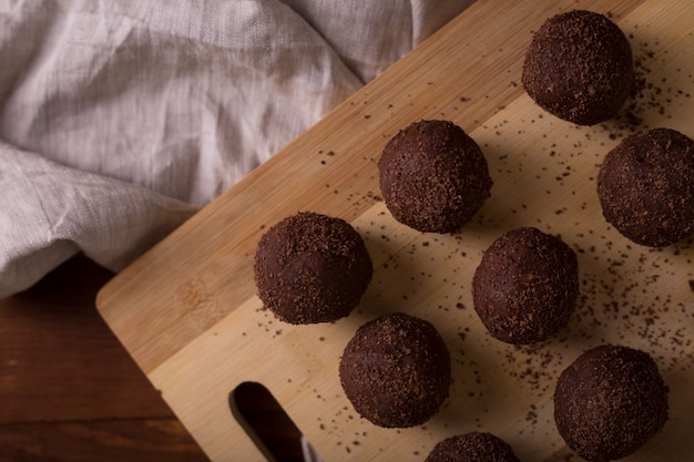 Kakaokugeln, Schokoladentrüffelkuchen an Bord auf Holztisch