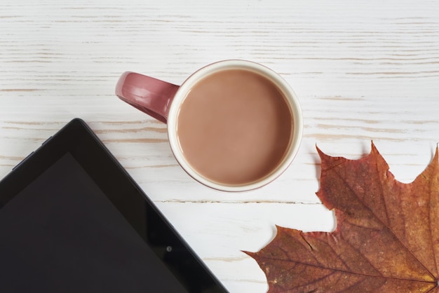 Foto kakaotasse herbstblätter und tablet-pc