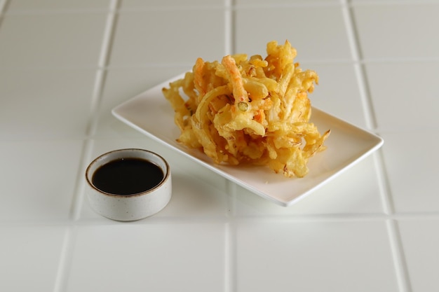 Kakiage tempura, verduras fritas servidas en plato blanco.