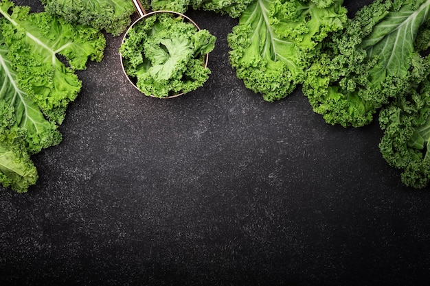 Kale Kohl Grüne Gemüseblätter Draufsicht auf schwarzem Hintergrund gesunde Ernährung vegetarische Kost