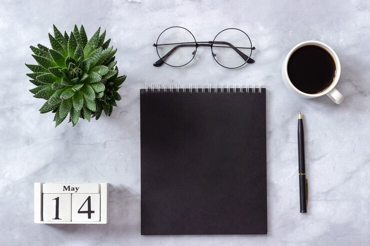 Kalender 14. Mai. Schwarzer Notizblock, Tasse Kaffee, Succulent, Gläser auf Marmor