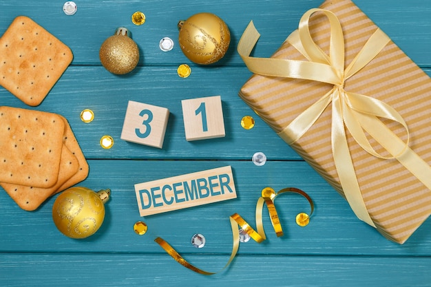 Kalender 31. Dezember mit Geschenkbox, Crackern und Weihnachtsschmuck