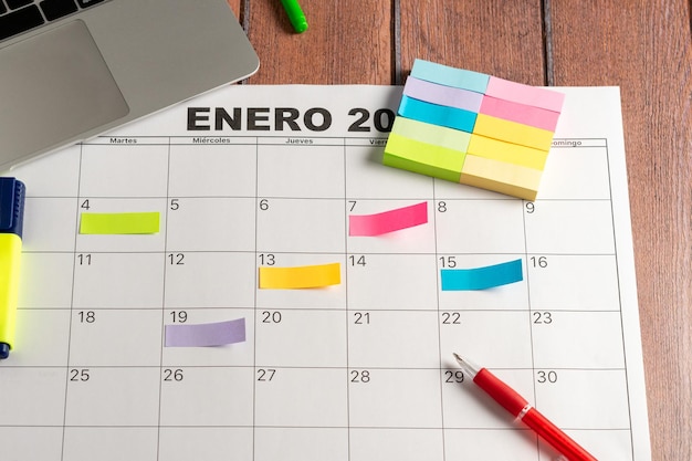 Kalender des Monats und mehrere farbige Haftnotizen, um die zu erledigenden Aktivitäten hervorzuheben