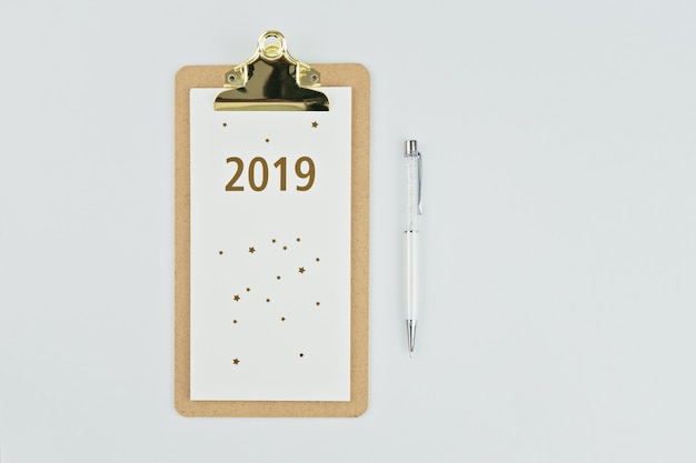 Kalender des neuen Jahres 2019 mit Notizbuch und Stift auf Weiß