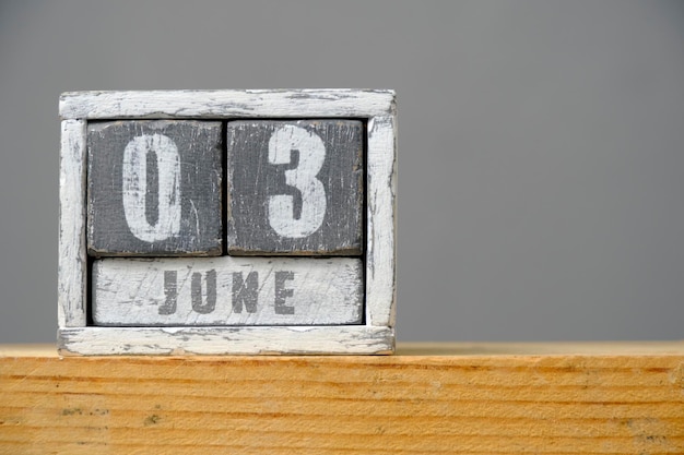 Kalender für den 3. Juni aus Holzwürfeln, die auf einem Regal auf grauem Hintergrund stehen. Mit einem leeren Platz für Ihren Text. Weltfahrradtag