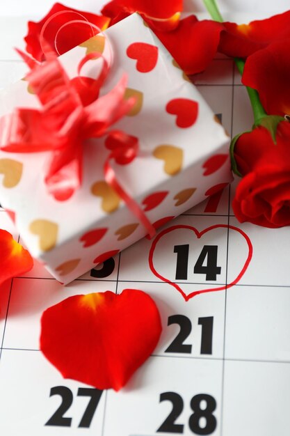 Kalender mit Datum vom 14. Februar Geschenkbox und Rosenblüten Valentinstag Konzept