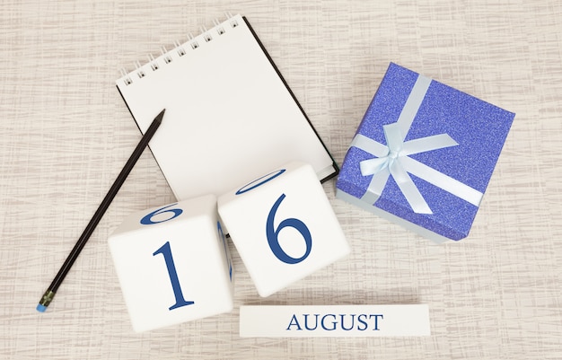 Kalender mit trendigen blauen Text und Zahlen für den 16. August und ein Geschenk in einer Box.