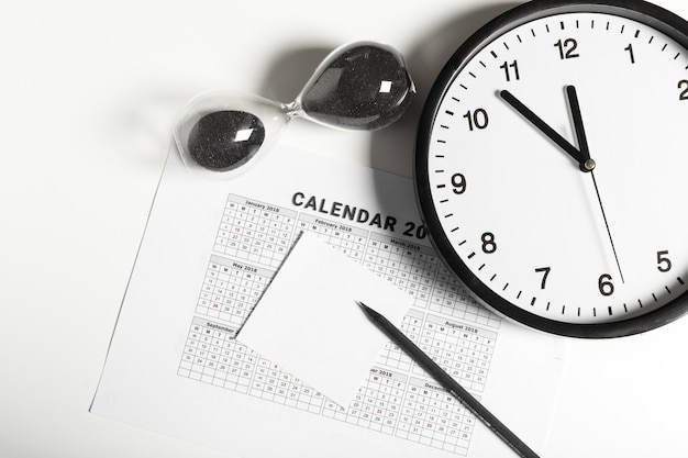 Kalender und Uhr auf weißem Hintergrund