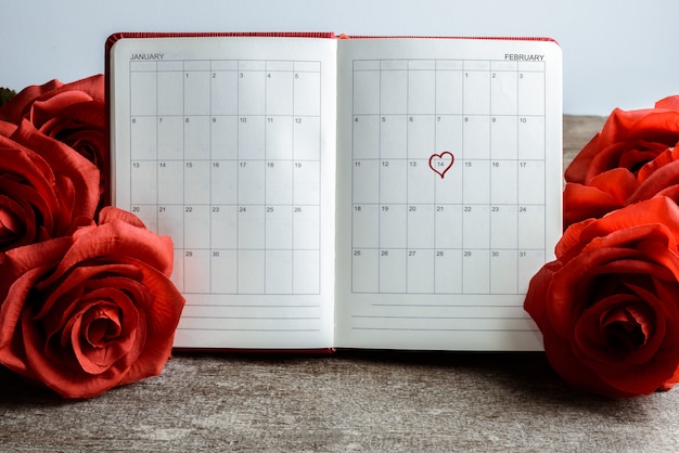 Kalenderprotokoll, Notizbuch mit Blumenstrauß aus roten Rosen