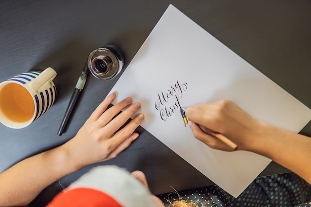 Kalligraph junge Frau schreibt Satz auf weißem Papier