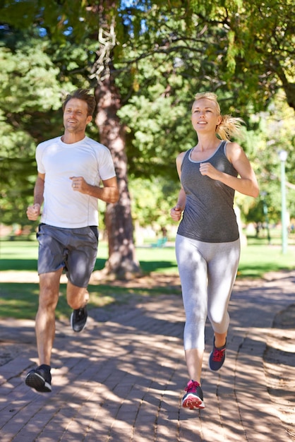 Kalorien verbrennen zu zweit Ein Paar in Sportkleidung beim Joggen durch den Park