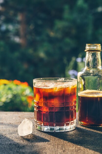 Foto kalt gebrühter kaffee in einem glas vor grünem hintergrund