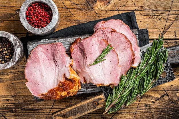 Kalt geräuchertes Schweinefilet mit Kräutern auf rustikalem Brett Holzhintergrund Ansicht von oben