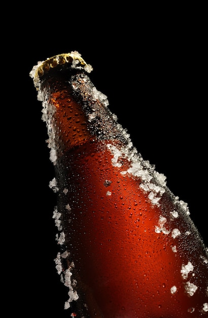 Kalte braune Flasche Bier mit Wassertropfen und Eis