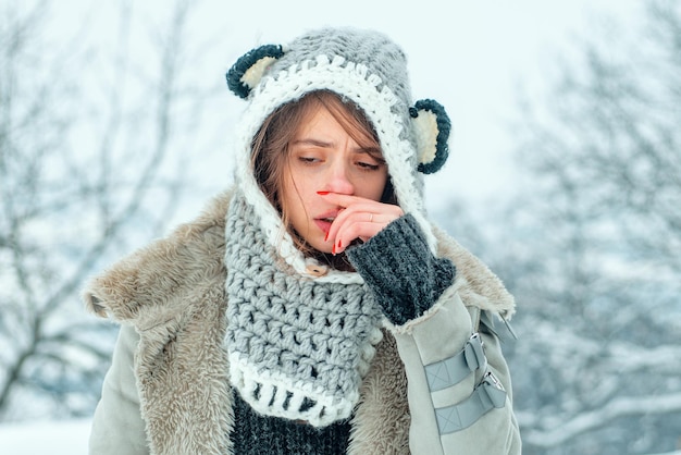 Foto kalte grippe wintersaison laufende nase zeigt kranke frau niesen im winterpark