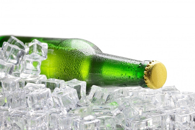 Kalte grüne Flasche Bier auf den Eiswürfeln lokalisiert auf weißem Hintergrund