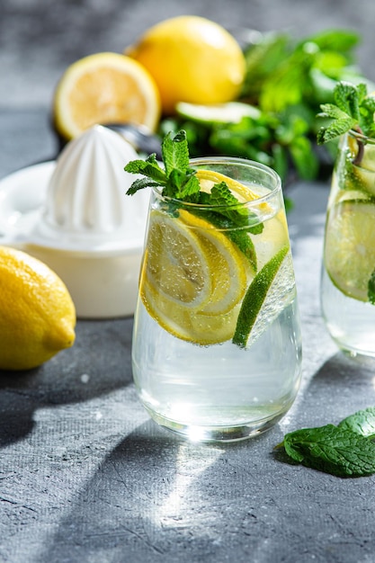 Kalte Limonade mit Minze, Zitrone und Limette in einem Glas. Zubereitung von Limonade