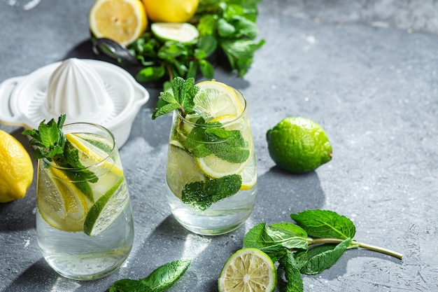 Kalte Limonade mit Minze, Zitrone und Limette in einem Glas. Zubereitung von Limonade