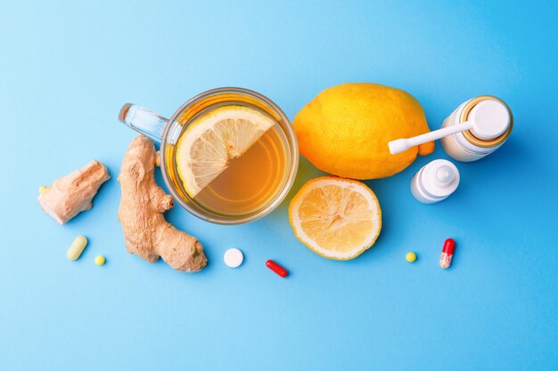 Kalte Medikamente Tee Zitrone und Ingwer auf blauem Hintergrund