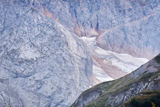 Kalte neblige Alpenlandschaft mit einem Gletscher versteckt zwischen den Ausläufern des Berges