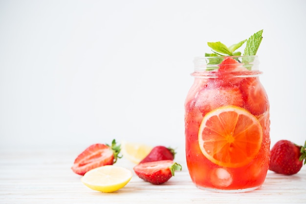 Kalte Sommererdbeerlimonade in einem Glas auf weißem Hintergrund, selektiver Fokus, Kopierraum