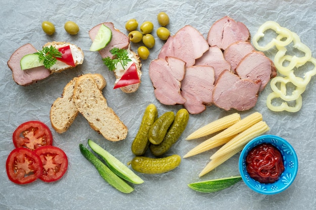 Kalte Vorspeise Aufschnitt Verschiedene Snacks auf einem weißen, zerknitterten Papier von oben