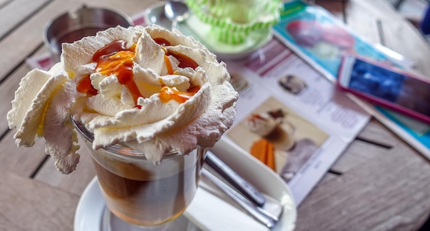 Kalter Kaffee mit Eis und zuckerhaltiger Sahne in einem Café-Tisch