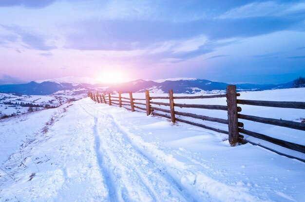 Kalter Morgen, schöne Landschaft mit schneebedeckten Bergen Magischer Wintersonnenaufgang auf einem Gipfel des Hügels