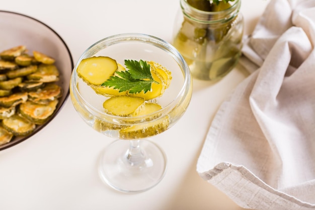 Kalter Pickleback-Cocktail mit Gurken und Petersilie in Gläsern auf dem Tisch