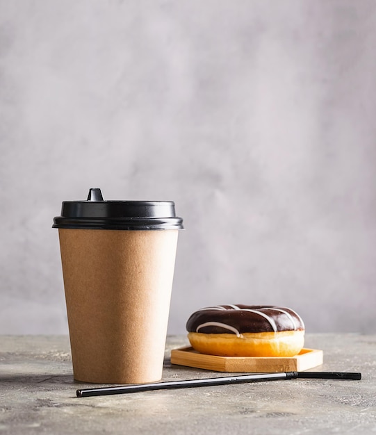 Kalter schwarzer Kaffee mit Eiswürfeln in hohem Glas und frischem Croissant Erfrischendes Kaffeegetränk auf einem grauen Tischhintergrund