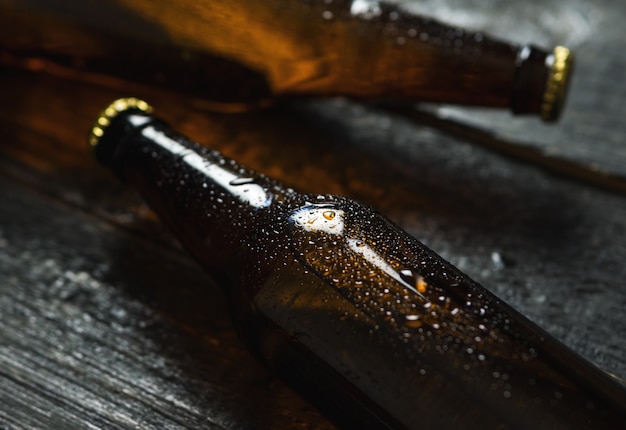 Kaltes Bier in Glasflaschen auf Holztisch
