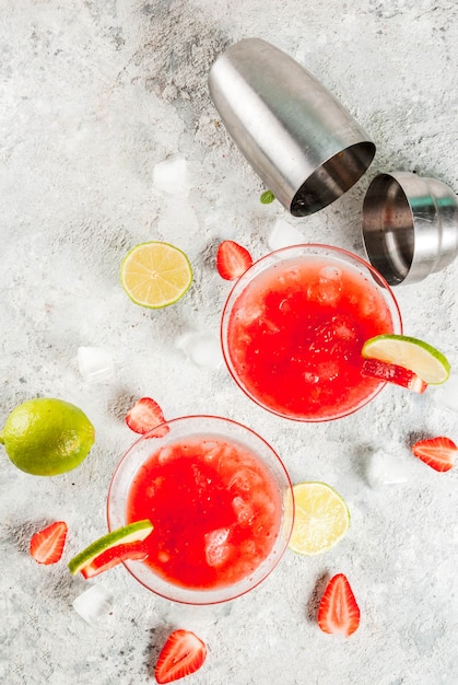 Kaltes Erdbeer-Margarita-Cocktail mit Eiskalk und frischen Beeren im hellgrauen Glashintergrund der Margarita