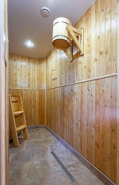 Kaltes Wasser aus einem Holzeimer für Abhärtung und gesunde LebensweiseEntspannen Sie in einer heißen Sauna