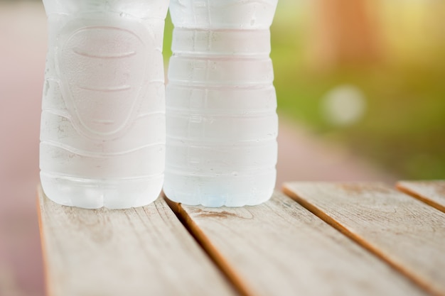 Kaltes Wasser in der Flasche auf Holzstuhl.