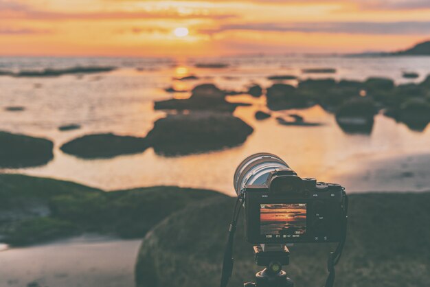 Kamera auf Stativ fängt farbenfrohen Sonnenaufgang ein