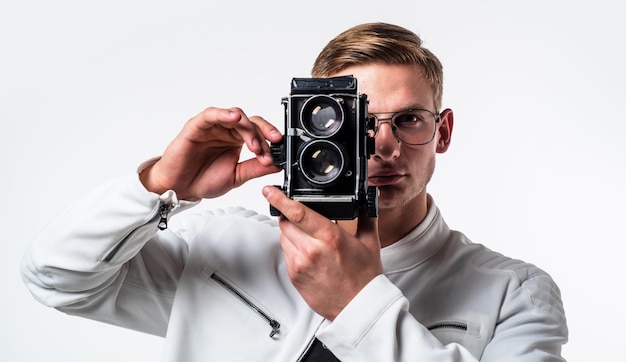 Kamera, die Ihnen buchstäblich eine Welt voller Möglichkeiten zur Verfügung stellt Junger Fotograf isoliert auf weiß Gut aussehender Mann fotografieren mit Vintage-Kamera Fotoausrüstung Shooting-Session